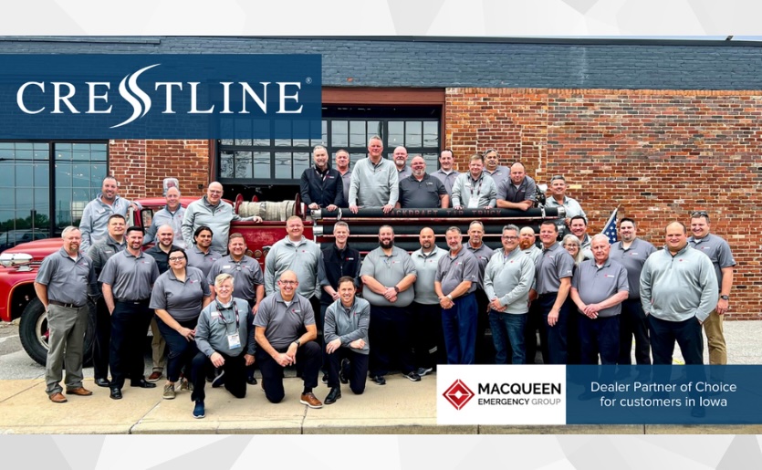 Group photo of the MacQueen Emergency Group team standing in front of a vintage red fire truck outside a brick building. The Crestline logo appears in the top left corner with a caption identifying MacQueen Emergency Group as the dealer partner of choice for customers in Iowa