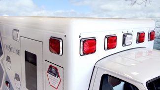 Upper side of a Crestline ambulance, showing red and white emergency warning lights and smooth radius corner design