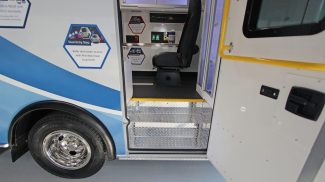 Side entry of a Crestline ambulance showing dual entry steps with diamond plate design