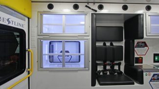 Interior of a Crestline ambulance featuring LED-lit aluminum storage cabinets and padded seating with safety restraints