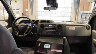 Driver cab of a Crestline ambulance featuring the steering wheel, dashboard controls, integrated communication system, and a center-mounted touch control panel for ambulance operations