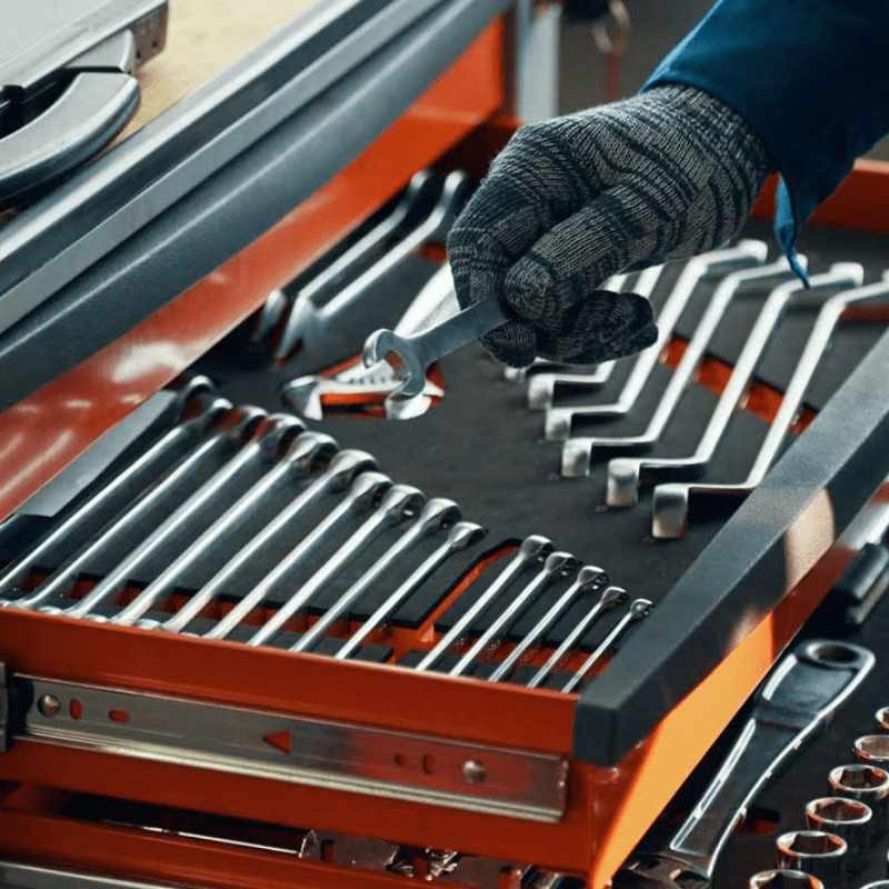Crestline technician wearing protective gloves selects a wrench from an organized tool drawer filled with neatly arranged hand tools