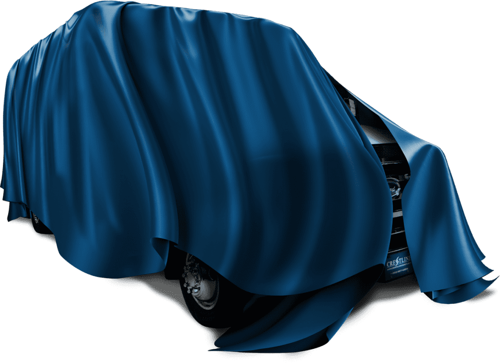 Crestline ambulance covered with a draped blue cloth, partially revealing the front grille