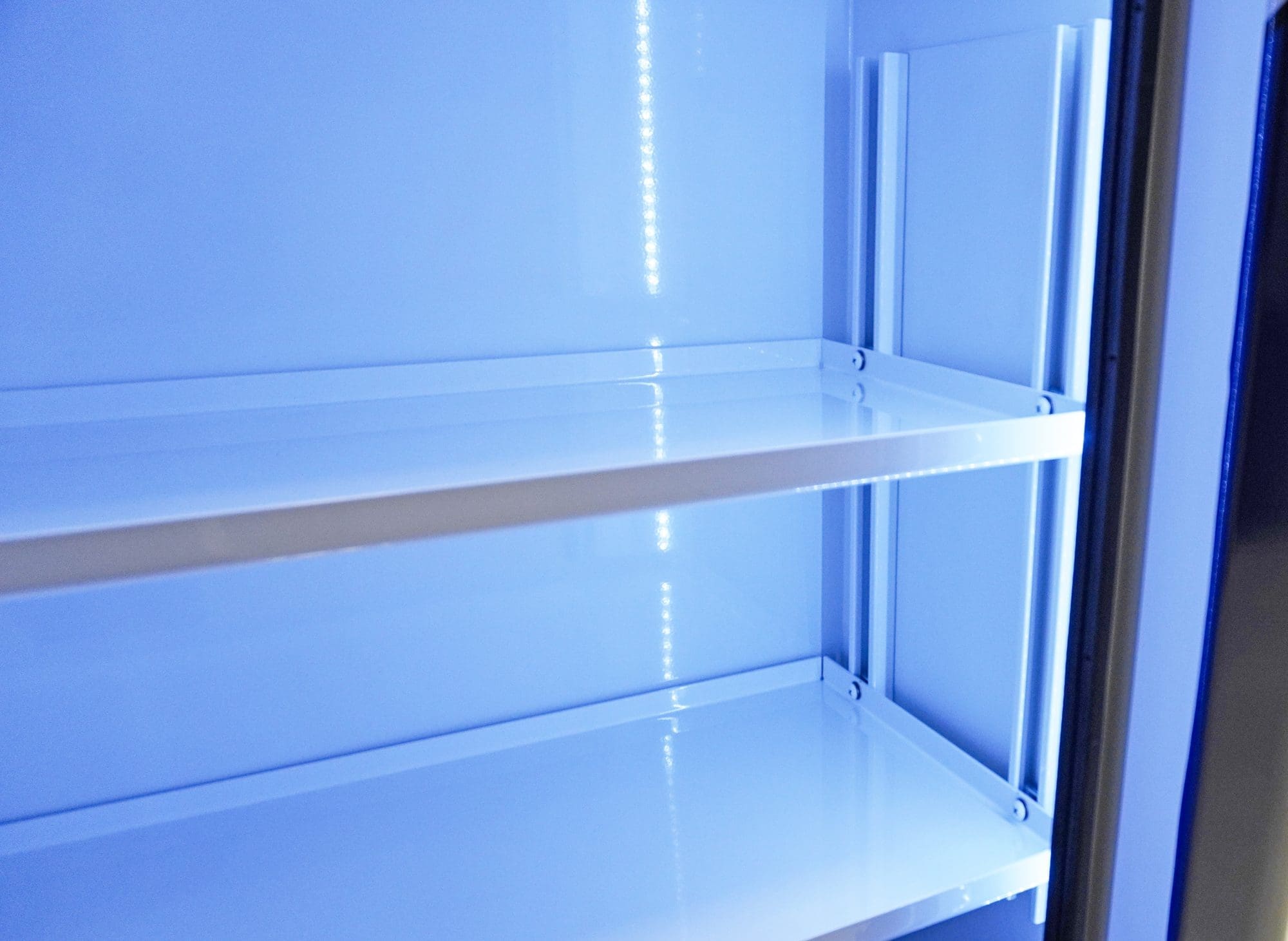 Close-up of illuminated interior storage shelves inside a Crestline ambulance cabinet, featuring smooth white surfaces and integrated LED lighting