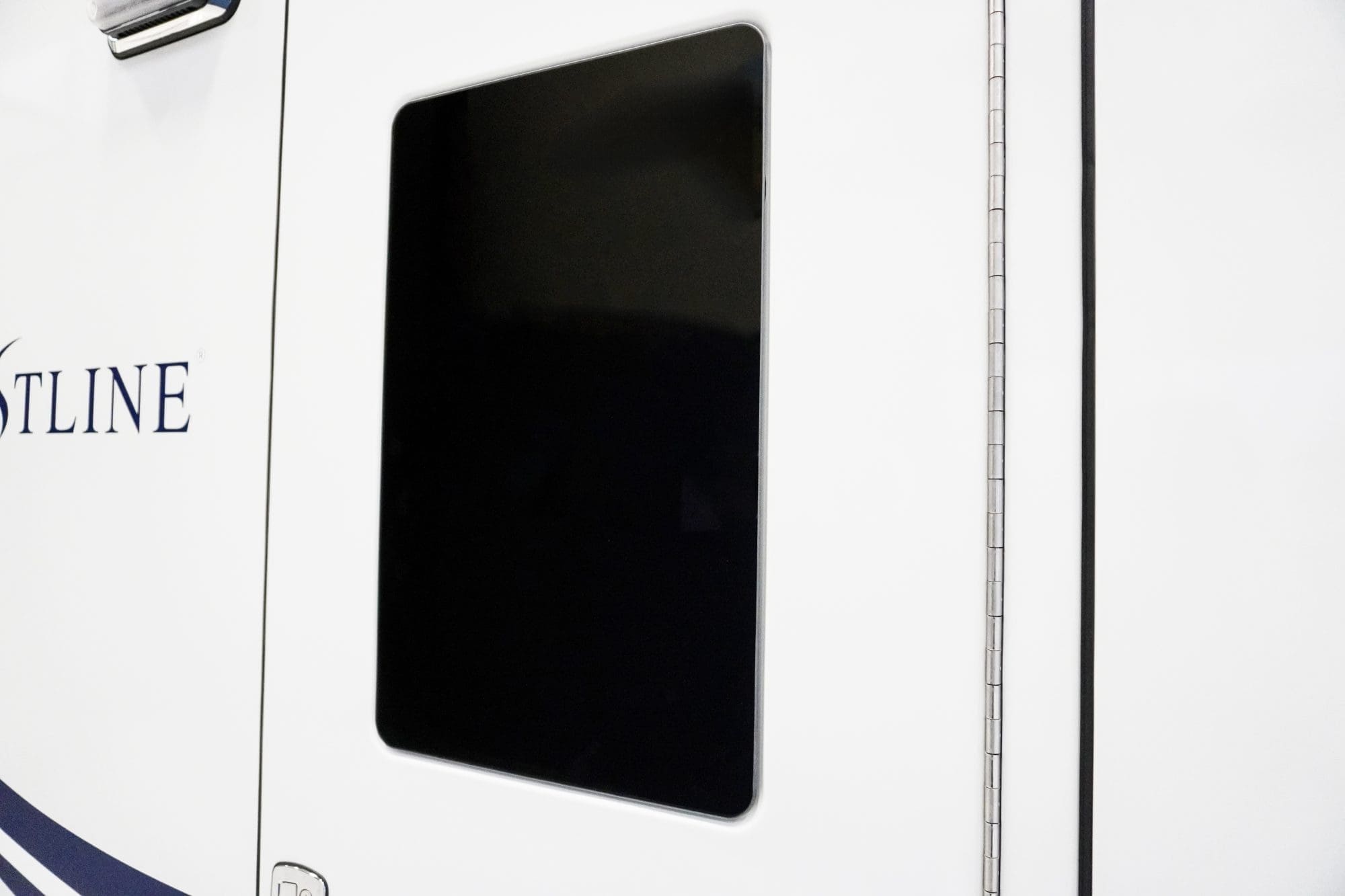 Close-up of a Crestline ambulance side door featuring a large, tinted rectangular window and smooth white exterior paneling