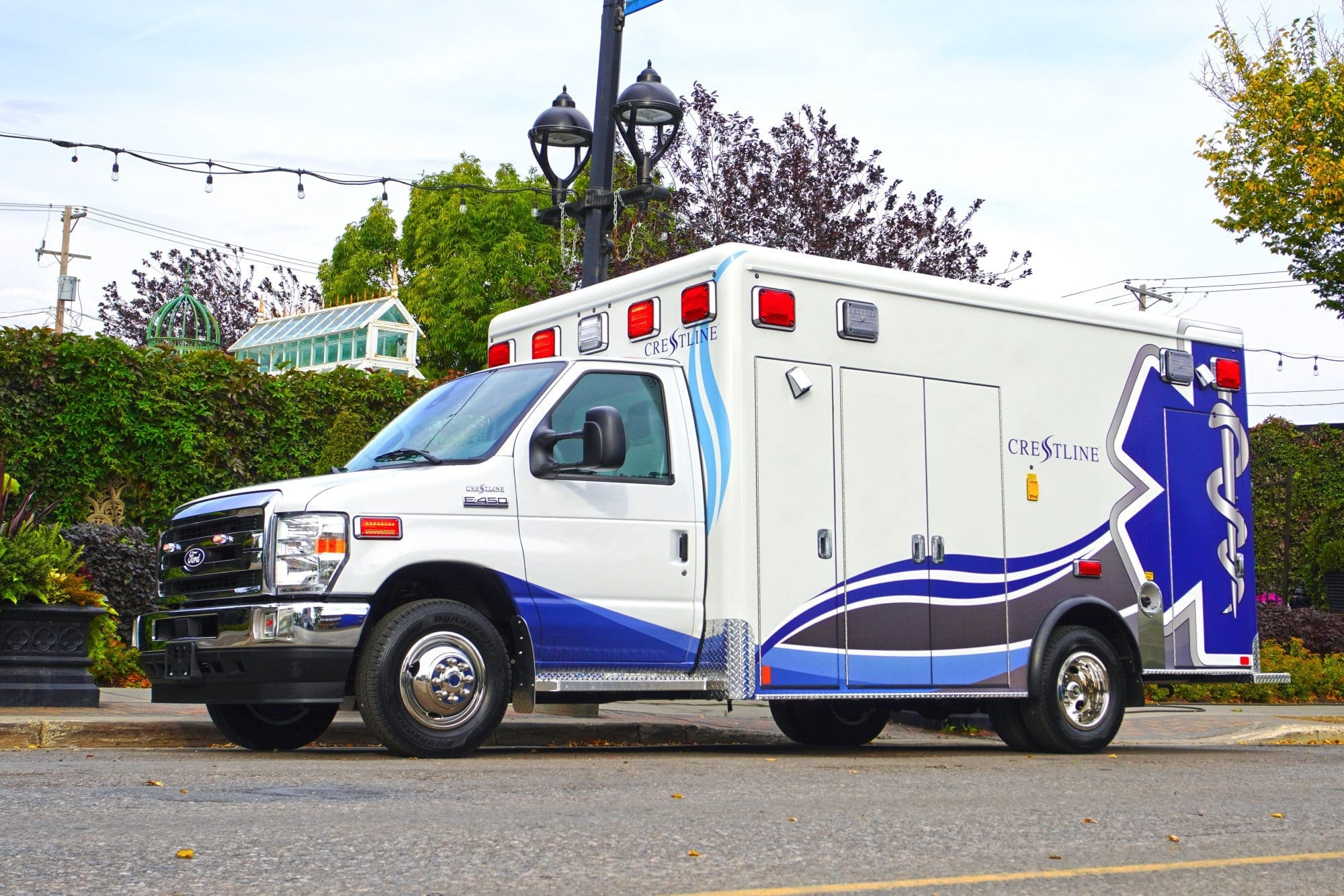 Crestline CCL 166 ambulance parked on a city street, highlighting its modern blue and white design with reflective graphics and safety lighting