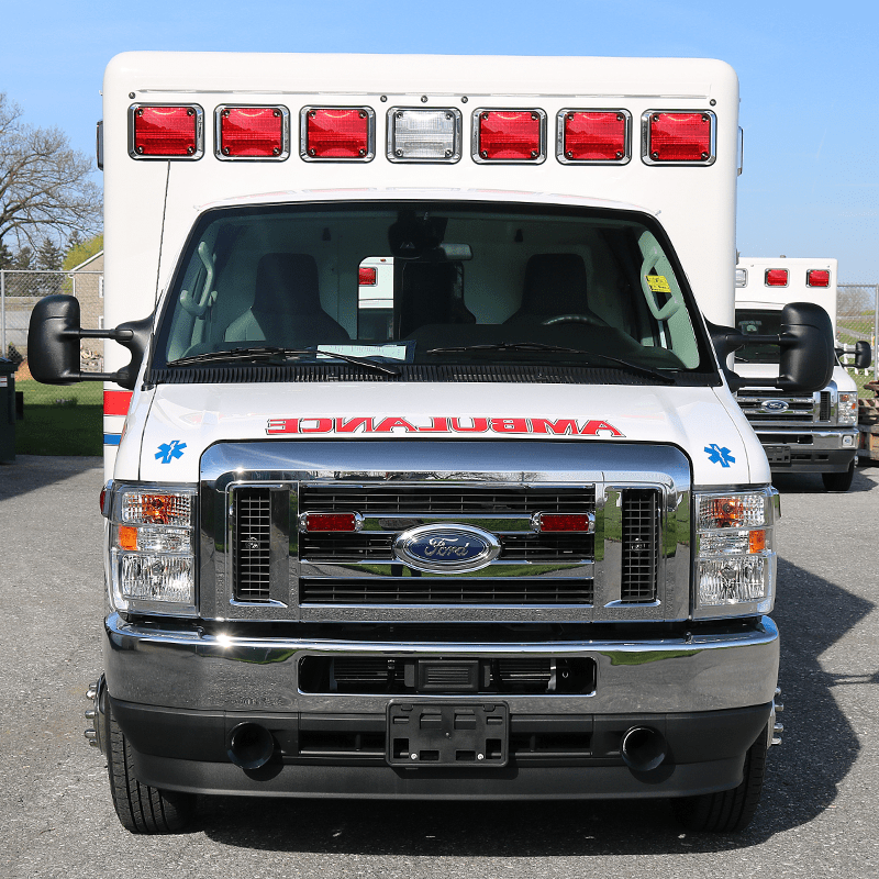 ambulance-chassis-1-ford Front view of a Crestline Ford ambulance with red and white emergency lights on the roof and bold 'AMBULANCE' lettering across the hood