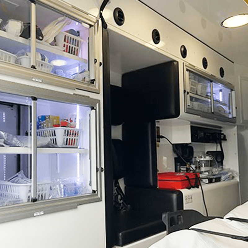 ambulance-model-2 Inside view of a Crestline ambulance showing stocked supply cabinets, seating, and medical equipment storage areas